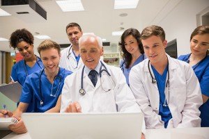 Medical students and professor using laptop at the university