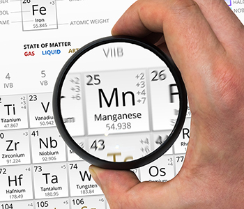 Manganese symbol - Mn. Element of the periodic table zoomed with magnifying glass