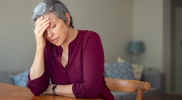 stressed senior woman at kitchen table