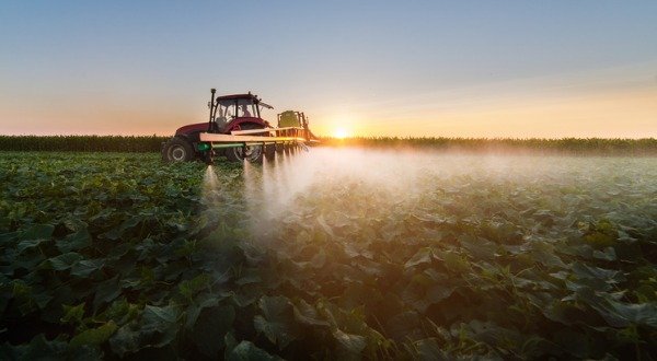tractor spraying pesticides containing glyphosate