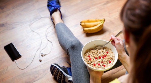 woman eating oatmeal in exercise clothes